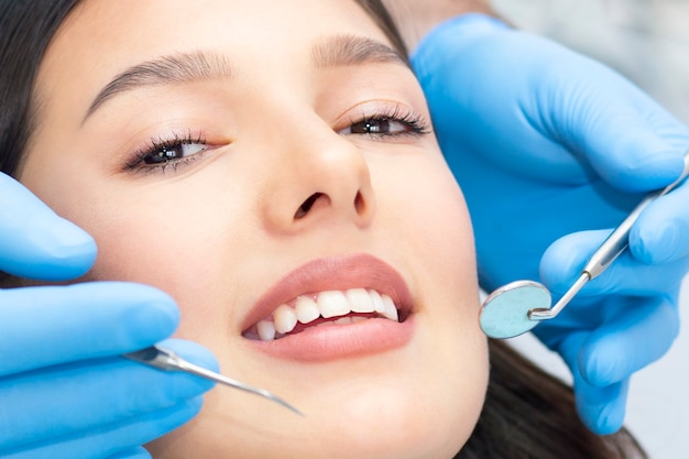 Concepto de salud de los dientes. Foto recortada de la boca de la mujer sonriente bajo tratamiento en la clínica dental