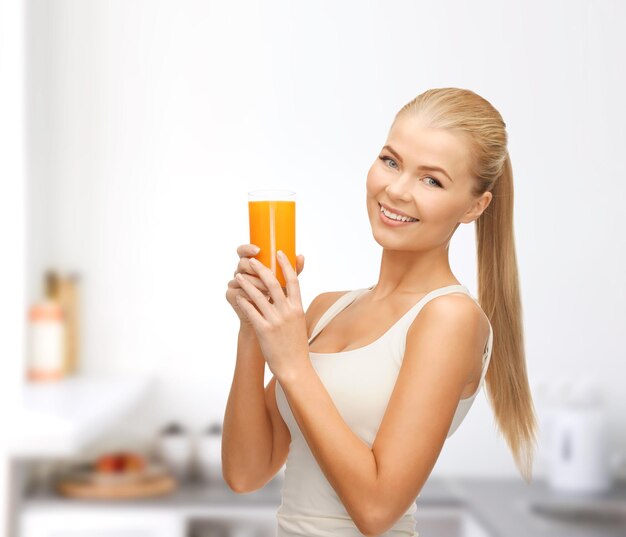 concepto de salud, dieta y comida - mujer joven sosteniendo un vaso de jugo de naranja