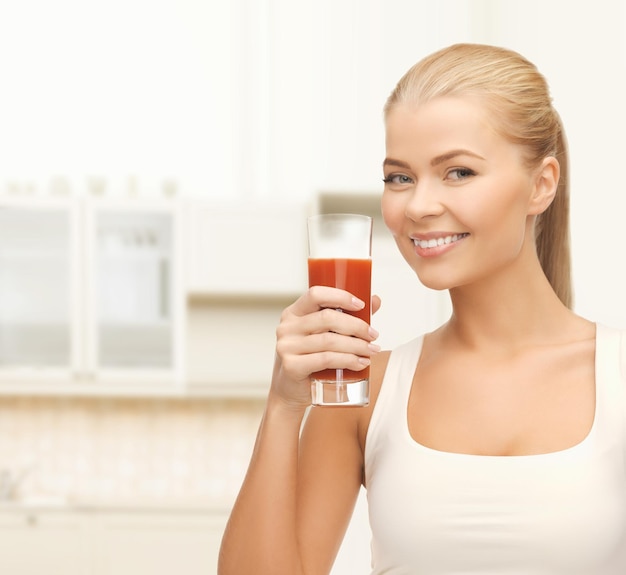 concepto de salud, dieta y comida - mujer joven sosteniendo un vaso de jugo de tomate