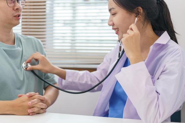 Concepto de salud Doctora usando estetoscopio con paciente para examinar la frecuencia cardíaca y pulmonar