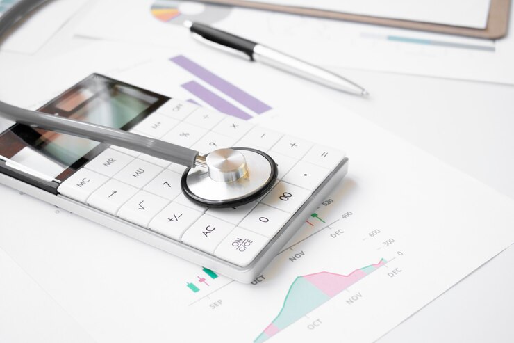 Concepto de salud financiera, estetoscopio tejiendo pilas de monedas de plata y oro y calculadora