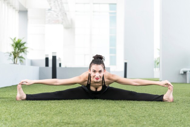 Concepto de salud y fitness. Mujer hermosa del deporte que hace una actitud de la yoga en casa.