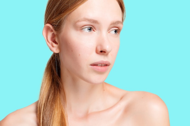 Concepto de salud, gente, juventud y belleza - Retrato de rostro de mujer de belleza. Hermosa chica modelo Spa con perfecta piel limpia fresca. Mujer rubia mirando a cámara y sonriendo. Concepto de juventud y cuidado de la piel.