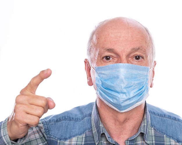 Concepto de salud. Hombre senior en máscara protectora posando en estudio sobre fondo blanco.