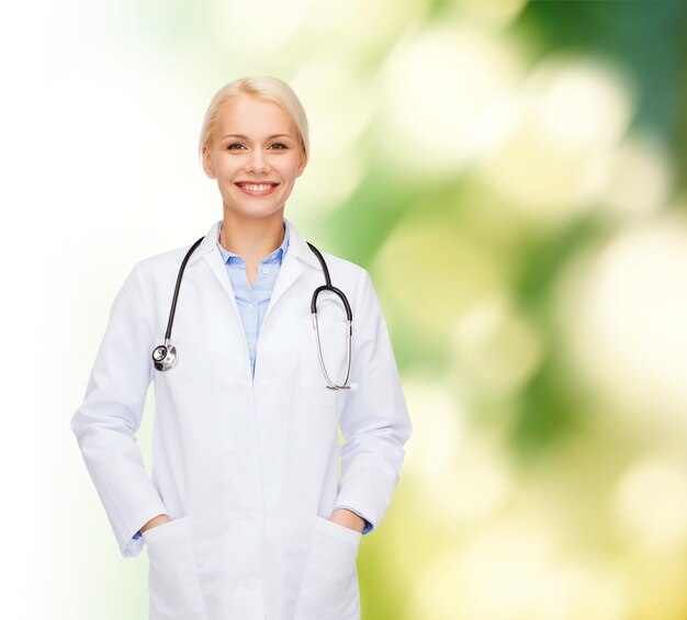 concepto de salud y medicina - doctora sonriente con estetoscopio sobre fondo azul