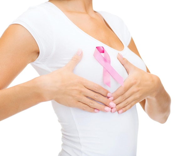 Concepto de salud y medicina - mujer en camiseta en blanco con cinta rosa de concienciación sobre el cáncer de mama que controla el pecho