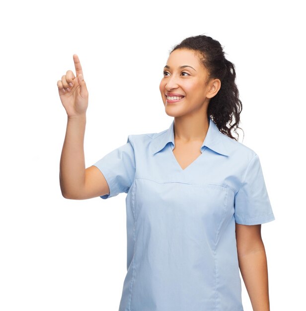 concepto de salud, medicina y tecnología - médico o enfermera afroamericano sonriente señalando algo o presionando un botón imaginario