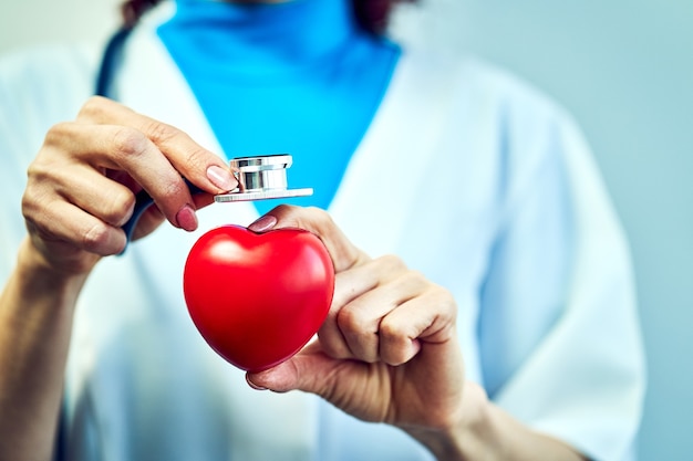 Concepto de salud, médico con un corazón en sus manos en un hospital.