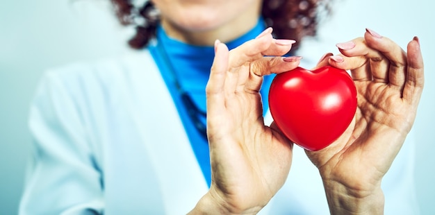 Concepto de salud, médico con un corazón en sus manos en un hospital.