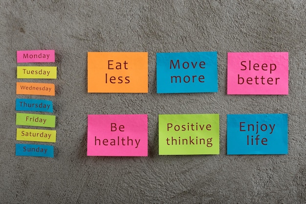 Concepto de salud y motivación Muchas notas adhesivas coloridas con palabras comer menos moverse más dormir