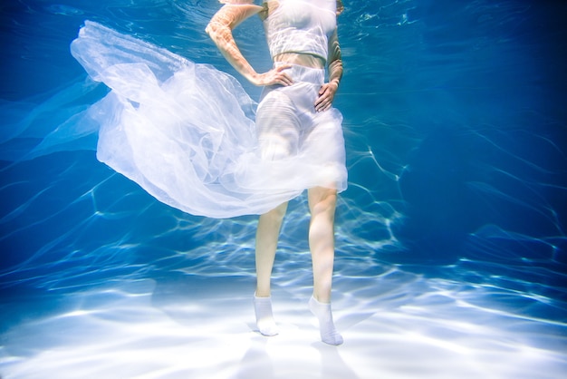 Concepto de salud de la mujer. Chica bajo el agua en blanco. ligereza, frescura y salud