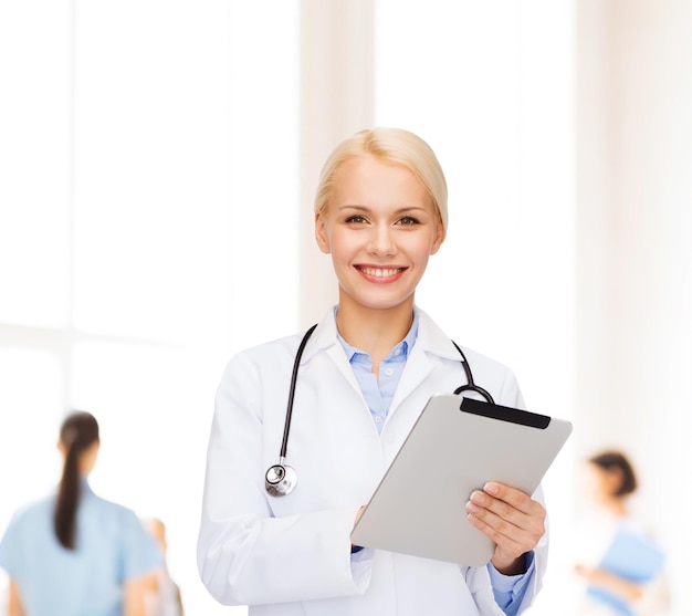 concepto de salud, tecnología y medicina - doctora sonriente con estetoscopio y computadora de tablet pc