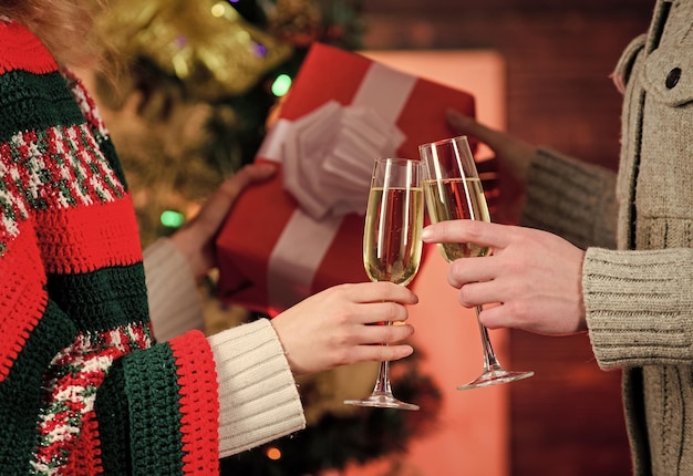 Concepto de salud Tradición de año nuevo Feliz Navidad Bebida alcohólica Vaso lleno de vino espumoso o champán Pasar un buen rato Brindis Copa de champán Copas de champán Pareja Dar regalo