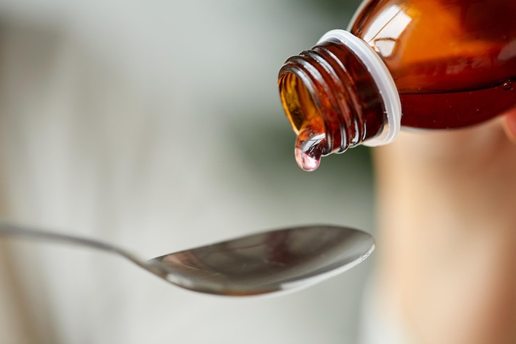 Foto concepto de salud, tratamiento y medicina - botella de medicamento o jarabe antipirético y cuchara