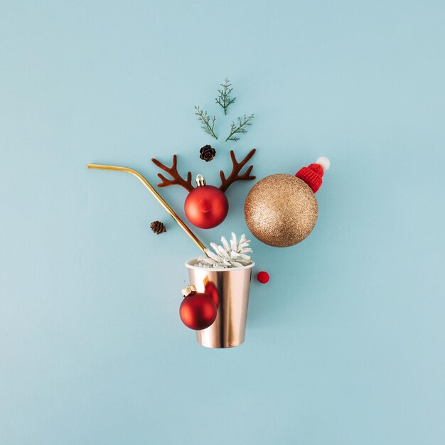 Concepto de saludo navideño con paja de vaso de papel y adornos sobre fondo azul