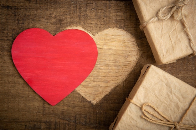 Concepto de saludos del Día de San Valentín Forma de corazón tallada en la madera con cajas de regalo Tarjeta de felicitación de San Valentín Espacio libre para su texto