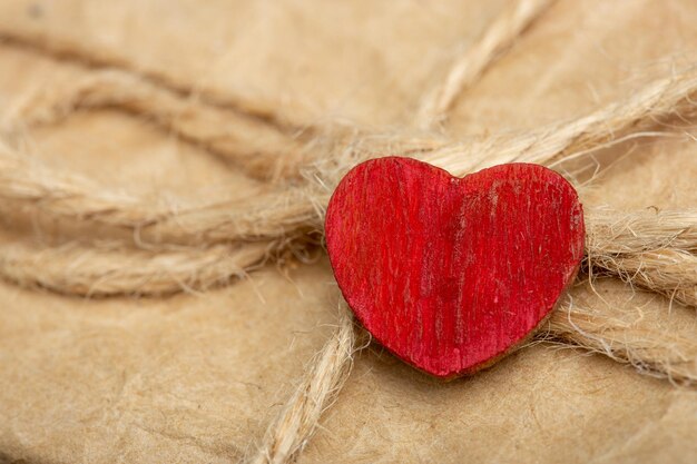 Foto concepto de saludos del día de san valentín pequeño corazón rojo de madera artesanal y caja de regalo de cerca en el fondo de madera tarjeta de felicitación de san valentín