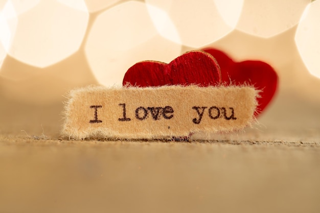 Concepto de saludos del Día de San Valentín Pequeño corazón rojo de madera y texto Te amo cerca de la tarjeta de felicitación de San Valentín