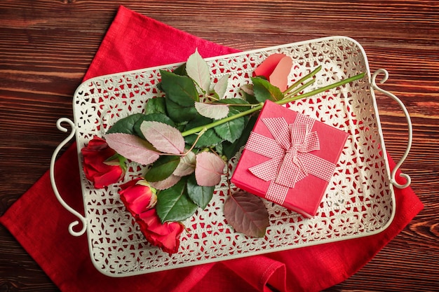 Concepto de San Valentín Bandeja con hermosas rosas y caja de regalo en la mesa