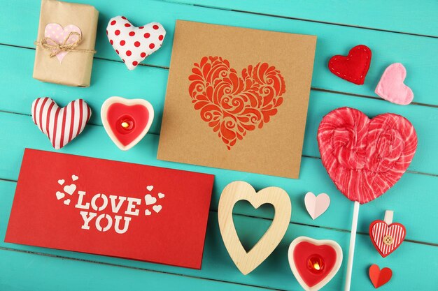 Concepto de San Valentín Composición de coloridos corazones hechos a mano y tarjetas de regalo sobre fondo de madera turquesa