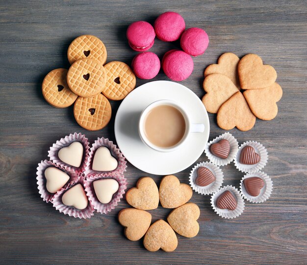 Concepto de San Valentín Composición de taza de galletas y dulces sobre fondo azul.