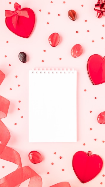 Foto concepto de san valentín corazones rojos y cinta sobre un fondo rosa