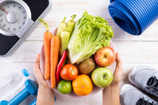 Concepto sano de la forma de vida, de la comida y del deporte en el fondo de madera blanco.