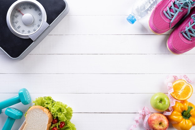 Concepto sano de la forma de vida, de la comida y del deporte en de madera blanco.