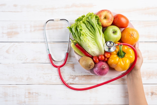 Concepto sano de la forma de vida, de la comida y de la nutrición en la tabla de madera blanca.