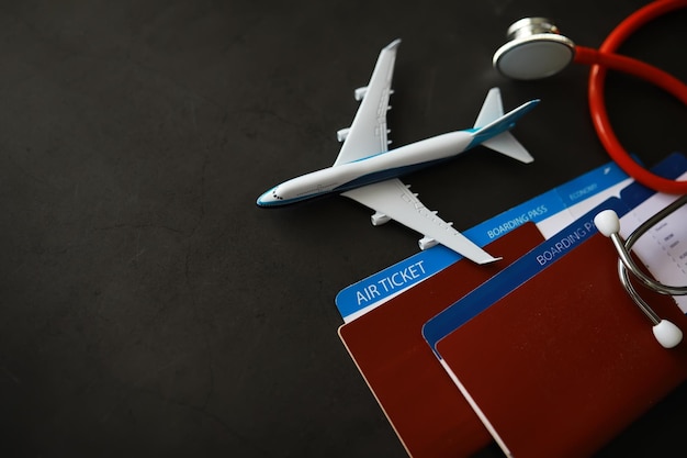 Concepto de seguro aéreo de pasajeros Tarjeta de embarque de pasaporte de avión y estetoscopio