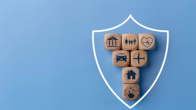 Foto concepto de seguro de vida con bloques de madera e íconos de varios tipos de seguros sobre un fondo azul