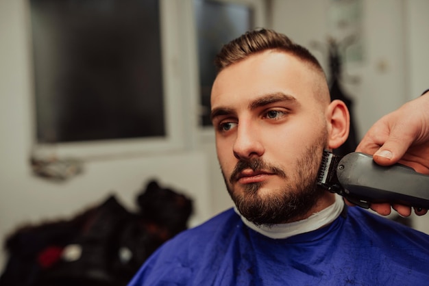 Concepto de servicio de cuidado del cabello de hombre joven en barbería