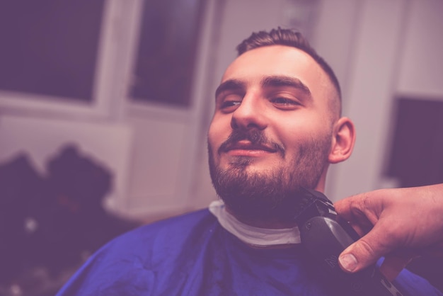 Concepto de servicio de cuidado del cabello de hombre joven en barbería