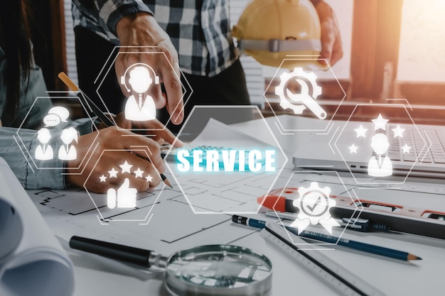 Concepto de servicio Reunión de ingenieros para un proyecto arquitectónico en un espacio de trabajo con icono de servicio en una pantalla virtual