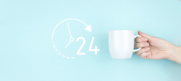 Concepto de servicio a tiempo completo. Mano de niña sostenga la taza de café de la mañana con signo 24 7 todo el día y toda la noche Icono sobre fondo azul.