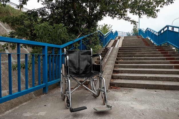 El concepto de silla de ruedas en las escaleras volcado, discapacitado, vida plena, paralizado. Problemas para la persona discapacitada.