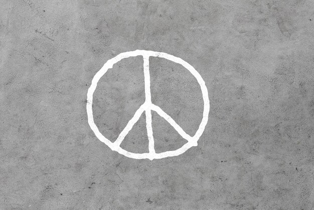 concepto simbólico, pacifista y hippie - dibujo de signos de paz en una pared de hormigón gris