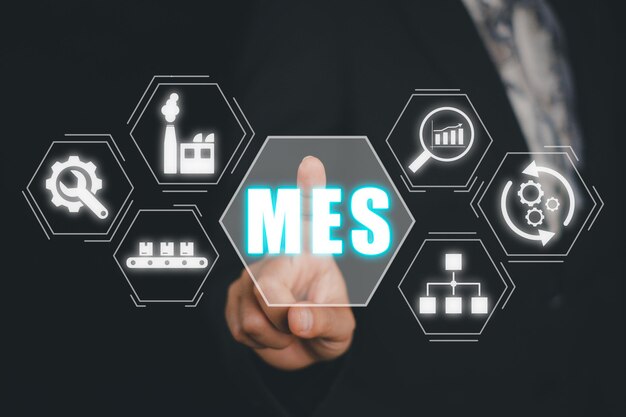 El concepto del sistema de ejecución de fabricación de MES El hombre de negocios toca con la mano el icono del sistema de ejecución de fabricación en la pantalla virtual