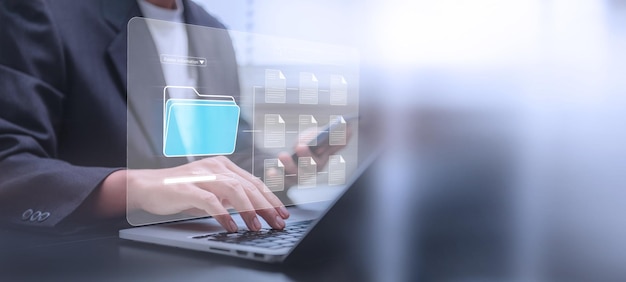 Concepto de sistema de gestión de documentos Empresario que utiliza una computadora portátil y un teléfono inteligente en la oficina después de ser configurado por un especialista en TI Software para el archivo de archivos corporativos