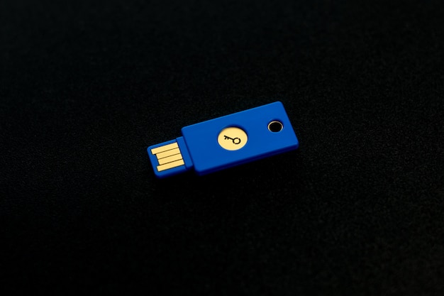 Concepto de sistema de seguridad. Unidad USB con forma de llave sobre fondo oscuro. Tema de tecnología y seguridad de datos.