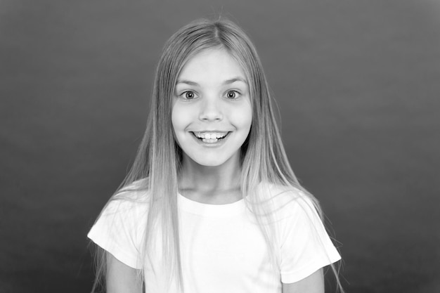 Concepto de sonrisa brillante Chica linda cara sonriente sobre fondo rojo Emocional niño feliz cara sonriente Emoción sincera Alegre adorable niña sonriendo Positivo y optimista Belleza sonriente