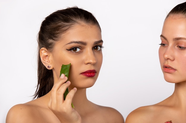 Concepto de spa y belleza foto ampliada de mujeres jóvenes con máscara de aloe vera aislada en la pared blanca