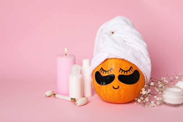 Concepto de spa con calabaza sobre fondo rosa