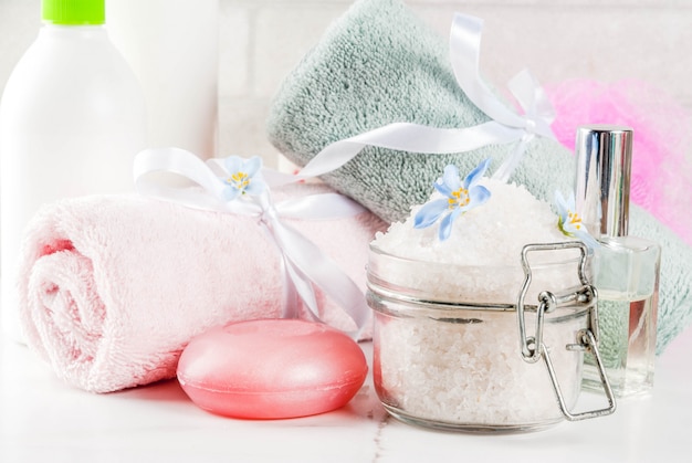 Concepto de spa relax y baño, sal marina, jabón, con cosméticos y toallas en el baño escena blanca