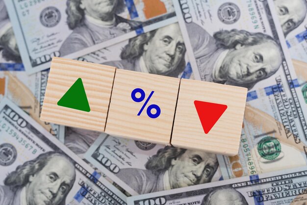 Concepto de tasas de interés financieras e hipotecarias Bloque de cubos de madera con icono de porcentaje y flecha hacia arriba y hacia abajo en dólares