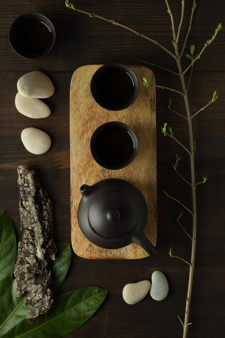 El concepto de té asiático sobre un fondo oscuro con plantas.