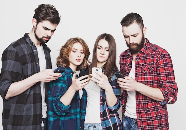 Foto concepto de tecnología e internetgrupo de jóvenes mirando sus teléfonos inteligentes