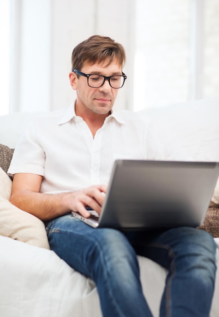 concepto de tecnología y estilo de vida - hombre que trabaja con la computadora portátil en casa