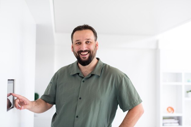 concepto de tecnología y hogar inteligente primer plano de las manos masculinas que señalan con el dedo a la computadora tablet pc integrada en la pared interior de la casa