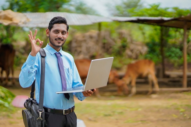 Concepto de tecnología: joven agrónomo o banquero indio que usa la computadora portátil.